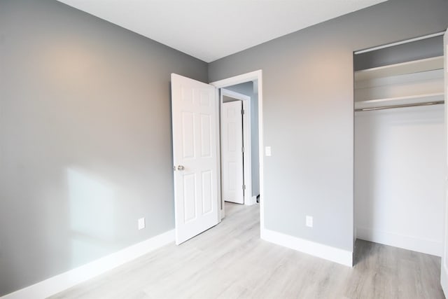 unfurnished bedroom featuring a closet and light wood-type flooring