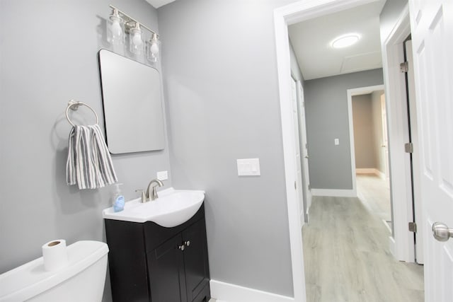 bathroom featuring vanity, hardwood / wood-style flooring, and toilet