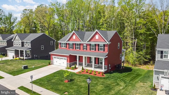 traditional home with a porch, a front lawn, driveway, and a garage