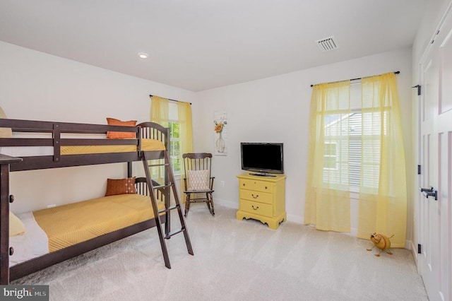 bedroom with light carpet, visible vents, and baseboards