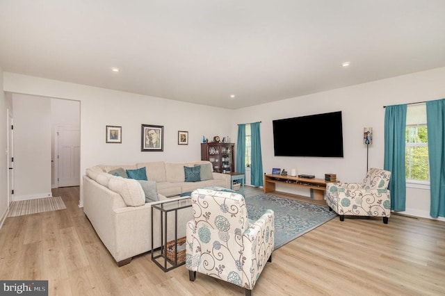 living area with recessed lighting, baseboards, and light wood-style flooring