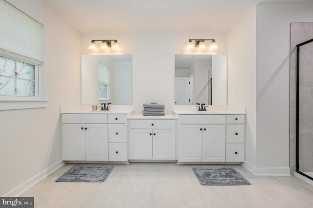 bathroom featuring two vanities, baseboards, and a sink