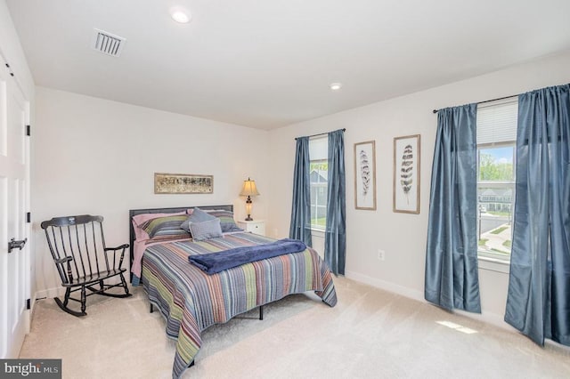 bedroom featuring baseboards, multiple windows, visible vents, and carpet