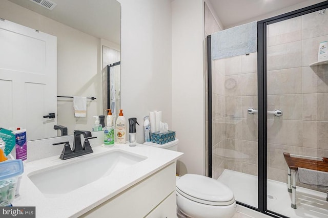 full bath featuring visible vents, vanity, a shower stall, and toilet