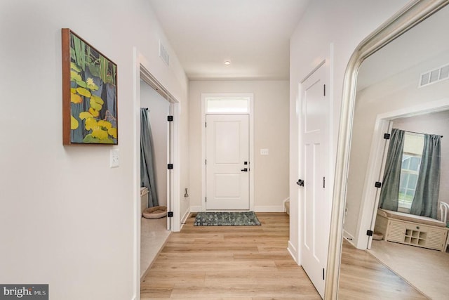 entryway featuring light wood-style floors, visible vents, and baseboards