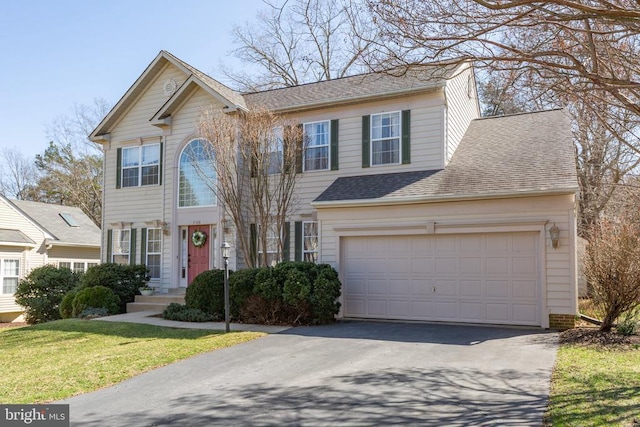 colonial home featuring aphalt driveway and roof with shingles