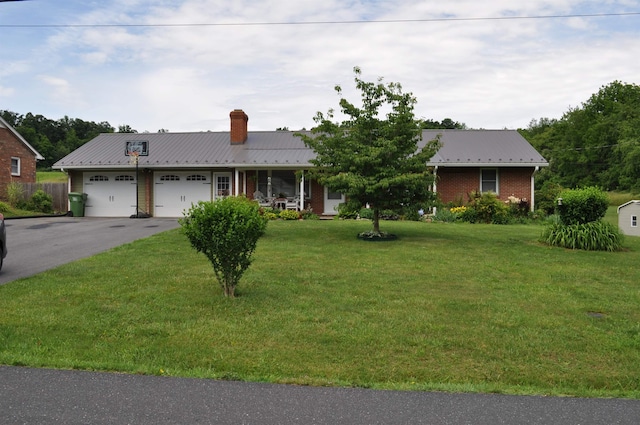 ranch-style home with aphalt driveway, a front lawn, brick siding, and a garage