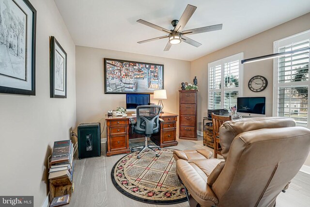 home office featuring light wood-type flooring and ceiling fan