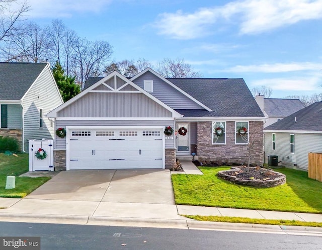 craftsman house with a garage, central AC unit, and a front yard