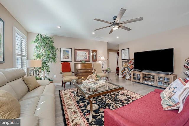 living room with ceiling fan and light hardwood / wood-style flooring