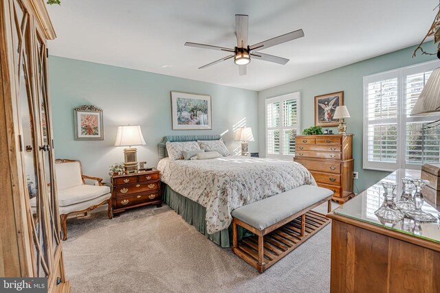 carpeted bedroom with multiple windows and ceiling fan