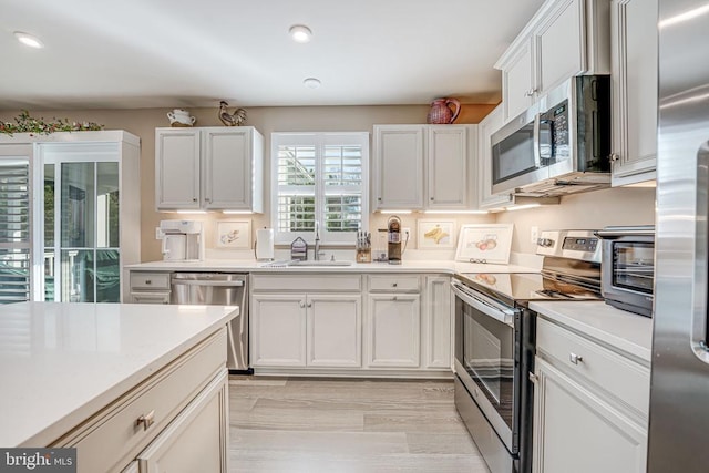 kitchen with white cabinetry, stainless steel appliances, and sink