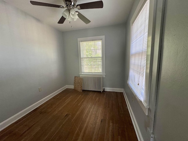 spare room with radiator and dark hardwood / wood-style floors