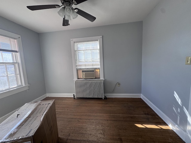 spare room with cooling unit, radiator, dark hardwood / wood-style floors, and ceiling fan