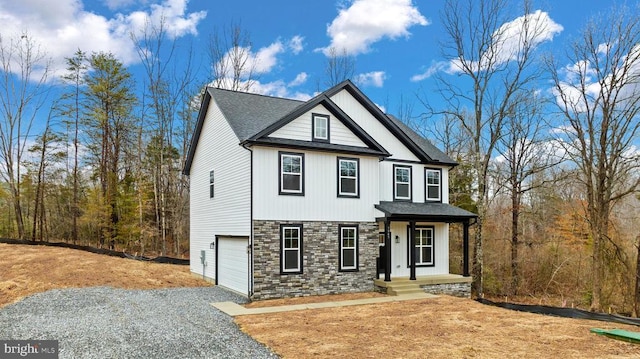 modern farmhouse featuring gravel driveway, stone siding, a garage, and roof with shingles