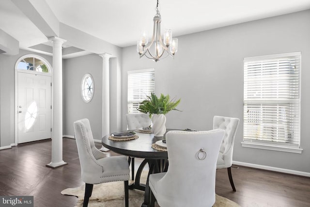 dining room featuring a wealth of natural light, a notable chandelier, wood finished floors, and ornate columns