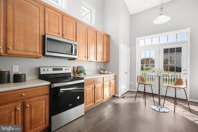 kitchen featuring light countertops, pendant lighting, dark wood-style floors, and stainless steel appliances