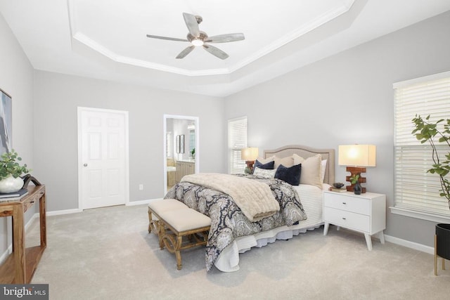 bedroom featuring a tray ceiling, light carpet, baseboards, and ornamental molding