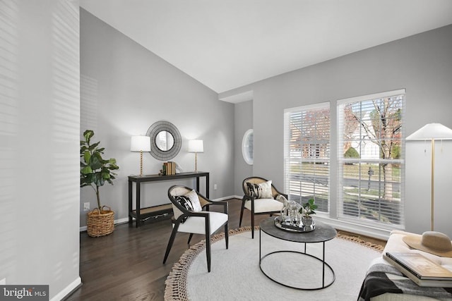 sitting room with baseboards, lofted ceiling, and dark wood-style flooring