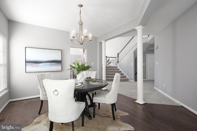 dining room with wood finished floors, baseboards, ornate columns, and a chandelier