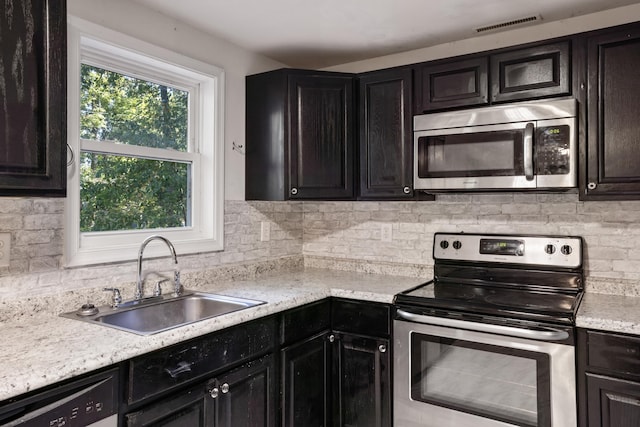 kitchen featuring tasteful backsplash, appliances with stainless steel finishes, and sink