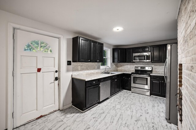 kitchen with tasteful backsplash, sink, and appliances with stainless steel finishes