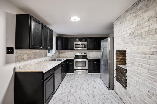 kitchen featuring tasteful backsplash, sink, stainless steel appliances, and brick wall