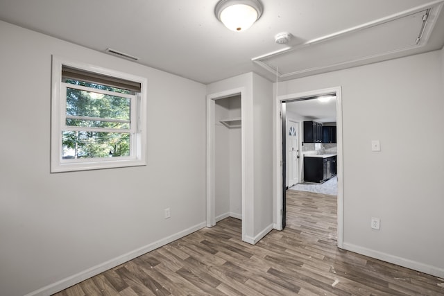 unfurnished bedroom with hardwood / wood-style flooring and a closet