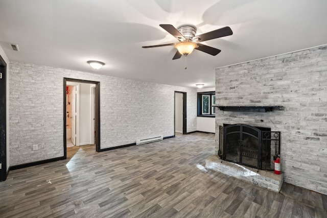 unfurnished living room with ceiling fan, a baseboard radiator, wood-type flooring, and a brick fireplace