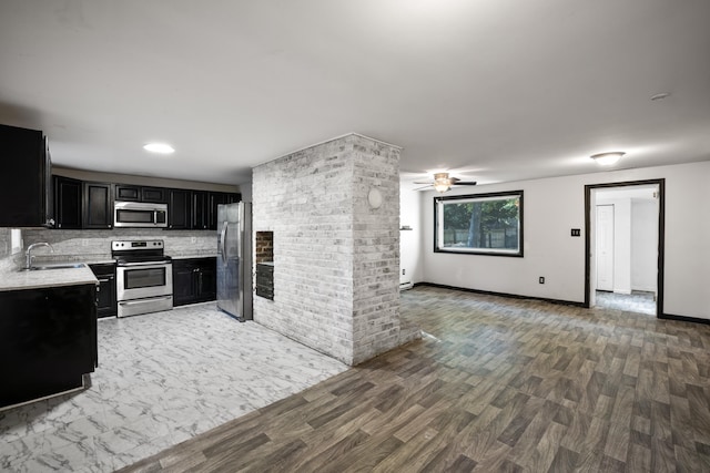 kitchen with decorative backsplash, appliances with stainless steel finishes, sink, and hardwood / wood-style floors