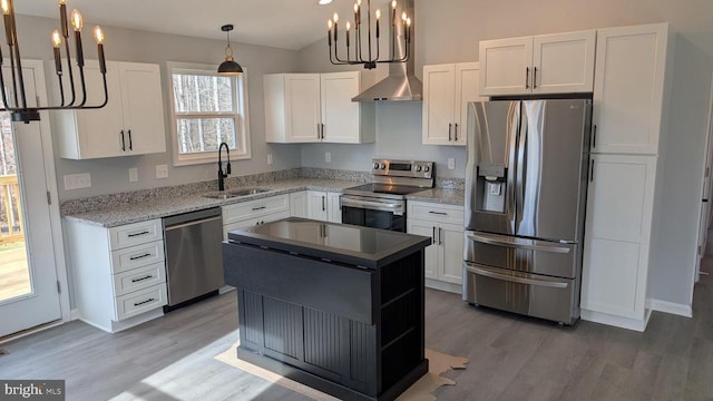 kitchen featuring appliances with stainless steel finishes, sink, white cabinets, hanging light fixtures, and a center island