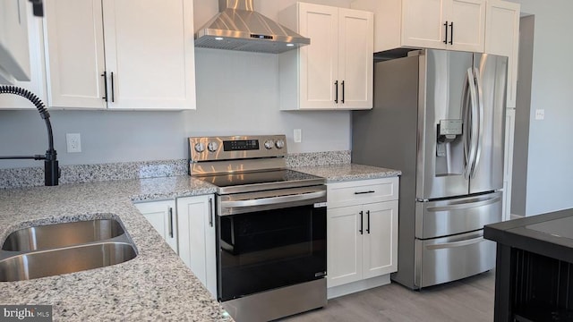 kitchen with white cabinets, stainless steel appliances, sink, and wall chimney range hood