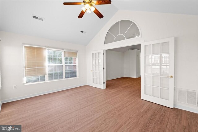 unfurnished room with high vaulted ceiling, visible vents, wood finished floors, and french doors