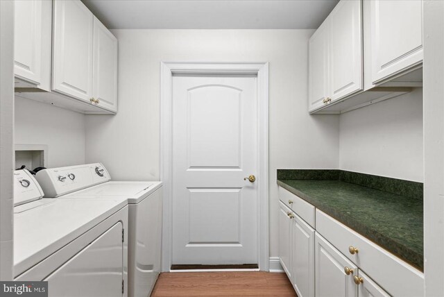 laundry room with cabinet space, independent washer and dryer, and light wood finished floors