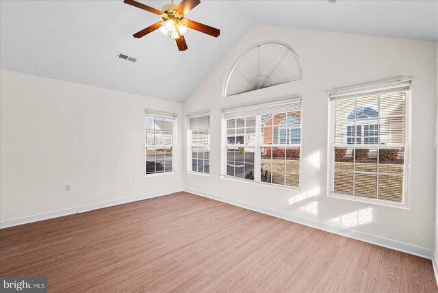 unfurnished sunroom with lofted ceiling, ceiling fan, visible vents, and a wealth of natural light