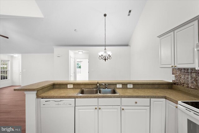 kitchen featuring pendant lighting, a wealth of natural light, white appliances, and a sink