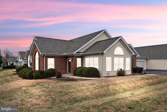 view of front of property with a garage and a yard