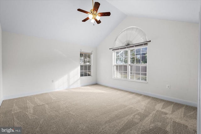 carpeted empty room featuring lofted ceiling, baseboards, and a ceiling fan