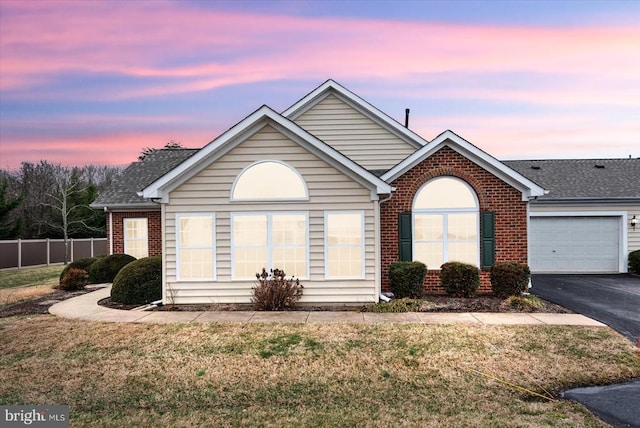 view of front of property featuring a garage and a lawn