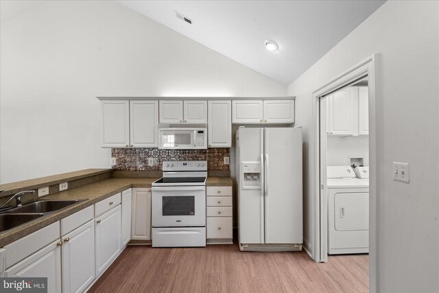 kitchen with washer and clothes dryer, tasteful backsplash, a sink, light wood-type flooring, and white appliances