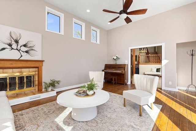 interior space featuring a fireplace, recessed lighting, wood-type flooring, a ceiling fan, and baseboards