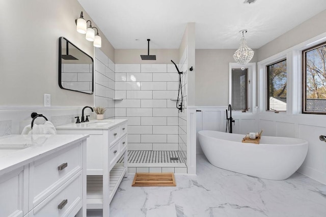 full bath with a soaking tub, wainscoting, a tile shower, and marble finish floor