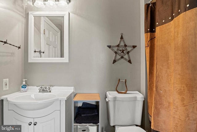 bathroom featuring vanity, curtained shower, and toilet