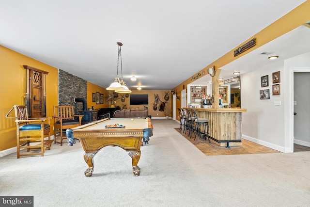 playroom featuring indoor bar, billiards, light carpet, and a wood stove