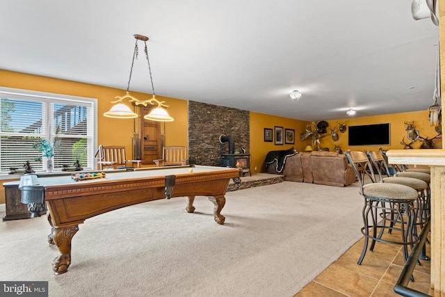 game room with pool table, light carpet, and a wood stove