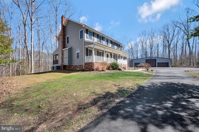 view of front of home featuring cooling unit, covered porch, a chimney, an outdoor structure, and a garage
