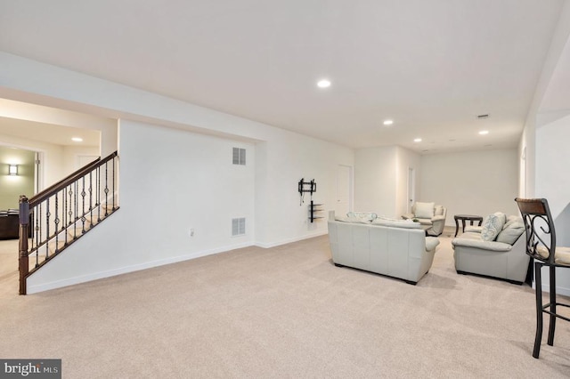 carpeted living area featuring recessed lighting, visible vents, baseboards, and stairs