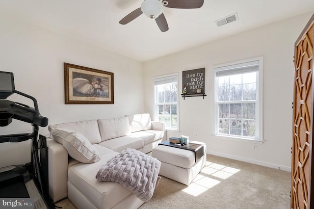 carpeted living area with baseboards, visible vents, and ceiling fan