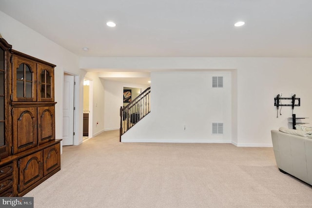 living area with recessed lighting, visible vents, light carpet, and stairs