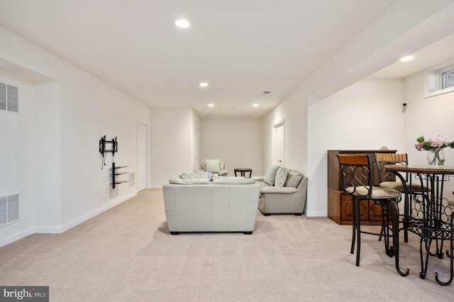 living room featuring recessed lighting, light colored carpet, visible vents, and baseboards